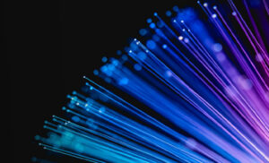 Abstract fiber-optic light burst in blue, purple, and pink against a black background.